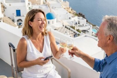 While I was finally enjoying my first approved break in four years on a quiet Santorini terrace, my father-in-law—the CEO—called and snarled, “Do you think you deserve this, taking vacations while others carry your weight? If laziness were a job title, you’d finally be qualified—don’t bother coming back.” I laughed, hung up, and clinked glasses with the stranger beside me—the CEO of our biggest rival. When I returned home, chaos followed…